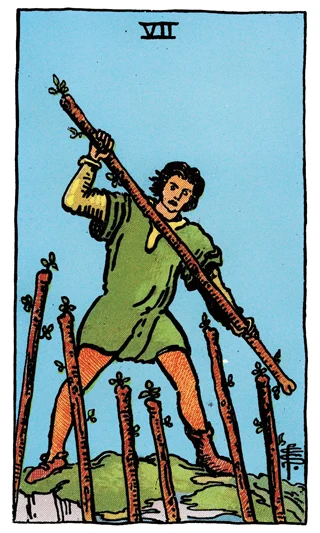 Seven of Wands Rider-Waite-Smith tarot card showing a figure on high ground defending against six raised wands.